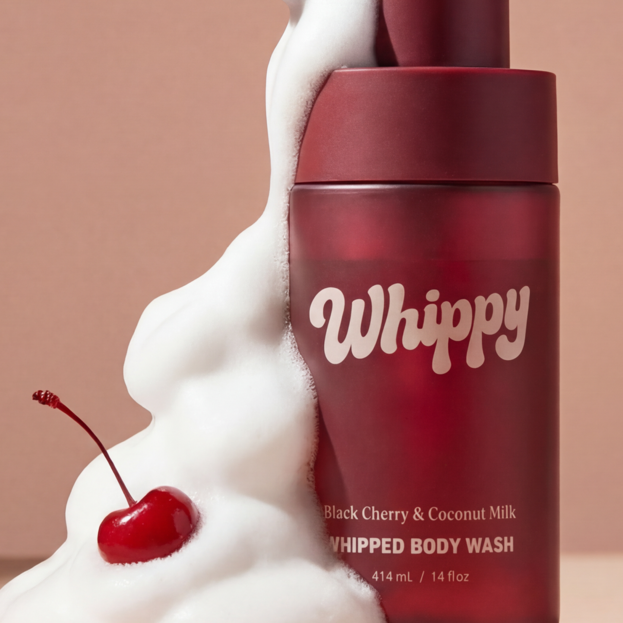 Whippy Black Cherry & Coconut Milk Whipped Body Wash bottle surrounded by rich foam lather and a fresh cherry.